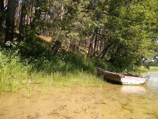 Fototapeta na wymiar Boat on Wdzydzkie lake coast.