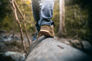 Close up Shoes of traveler walking on wood in forest, Travel concept