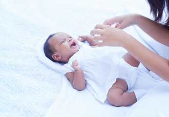 Beautiful mother playing with her newborn baby in garden. Family love lifestyle Asia mother’s day concept.