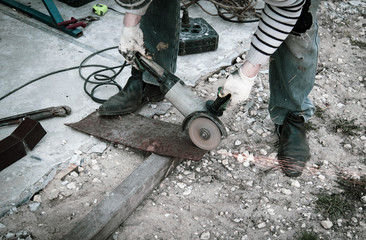 A worker cuts metal at a construction site