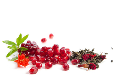 Parts of a pomegranate with pomegranate seeds and leaves, flowers, dry green tea with carcade  isolated on white background