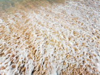 Golden sand and water on the seashore as a background
