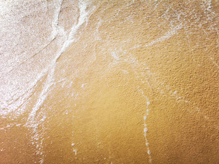 Golden sand and water on the seashore as a background