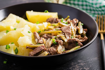 Stew beef, pieces of beef stewed with pickled cucumber in russian style. Beef stroganoff and boiled potatoes.