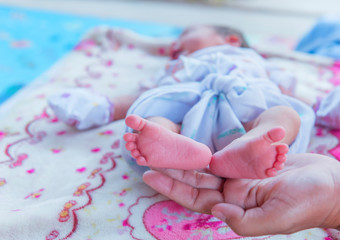 Parent holding in the hands feet of newborn baby.