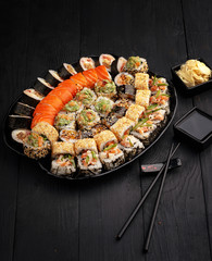 Traditional Japanese sushi food rolls on a black wooden background