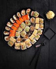 Traditional Japanese sushi food rolls on a black wooden background