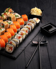 Traditional Japanese sushi food rolls on a black wooden background