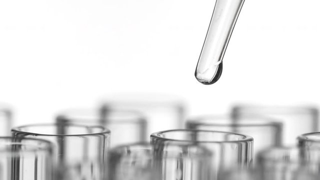 Closeup shot of scientist dripping liquid into test tube