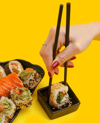 A set of traditional Japanese sushi rolls on a yellow background