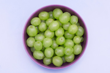green grapes in purple bowl on blue background