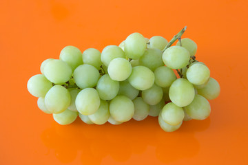 closeup green grapes on orange background