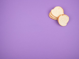 Sliced white bread on a purple background.