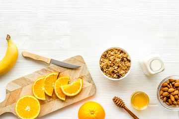 Vegetarian breakfast with granola and fruits on white background top-down frame copy space