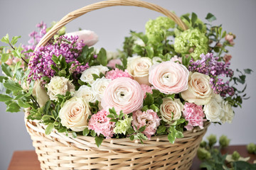 Fototapeta na wymiar Spring bouquet in a wicker basket.. Learning flower arranging, making beautiful bouquets with your own hands. Flowers delivery