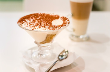 Tiramisu in a glass sprinkled with cocoa, trace from a spoon