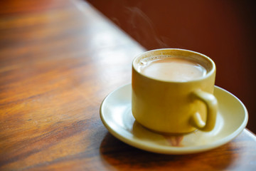 Tea in cup with saucer on wooden table 