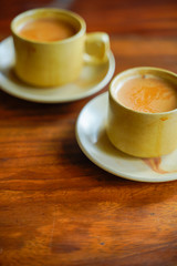 Tea in cup with saucer on wooden table 