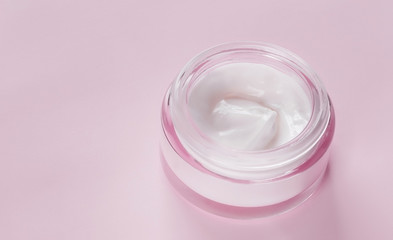  jar of face cream with a texture on a pink background