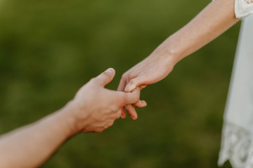 guy holds the hand of a girl with a blurry background