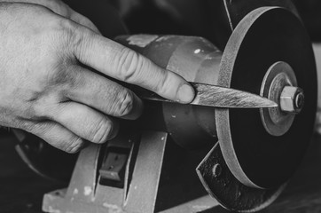 Sharpening the knife on an electric emery.