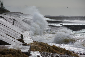 Big splash of water. Waves hitting concrete sea wall pier