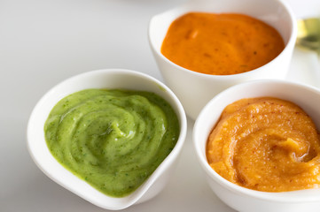 Famous Canary Islands mojo or sauces Mojo picon, Mojo verde and Almogrote in white elegant bowl on the restaurant table.