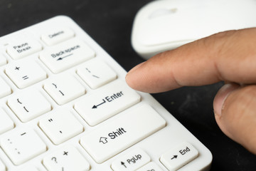 his finger put on the enter text of computer keyboard