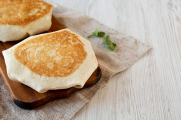 Tasty Homemade Beef Crunchwrap Quesadilla on a rustic wooden board, low angle view. Space for text.