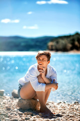 Vertical portrait of beautiful healthy short haired woman visiting beach on sunny holiday vacation trip, looking smiling, outdoors. Female joyful expression, active recreation adventure lifestyle