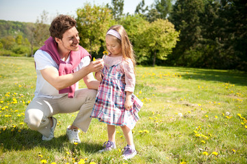 Fototapeta premium Happy family. Father with daughter on a meadow.
