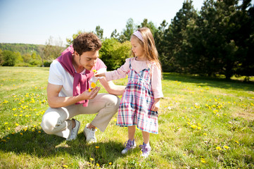 Fototapeta premium Happy family. Father with daughter on a meadow.