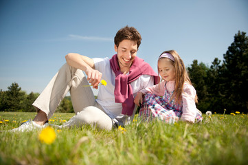 Fototapeta premium Happy family. Father with daughter on a meadow.