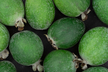 Feijoa fruit isolated at black background. Scientific name Acca sellowiana. Top view. Healthy and balanced diet eating concept. Fresh fruits concept.