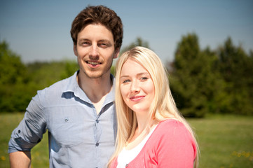 Happy young couple in love on a meadow