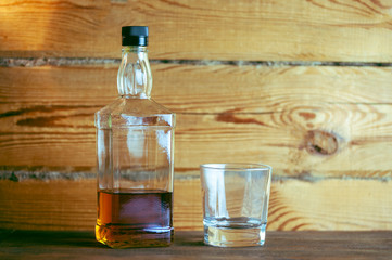 a bottle of whiskey and a glass on a wooden table
