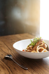Spaghetti Seafood: Italian Spaghetti with Tiger Prawns, Squids, Mussels Cooked in Olive Oil, Chilies and Garlic. Served in a Warm Plate on Wooden Table with Window Light.
