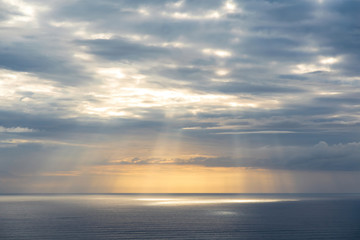 Aerial view of gray evening clouds over Tasman sea coast at Piha beach with run rays