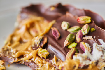 A piece of delicious chocolate cake decorated with nuts with caramel filling inside.