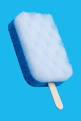Sponge popsicle on a stick isolated on blue background