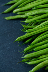 string beans on dark stone background