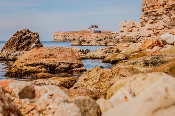 Black Sea red rocks coastline. Cape Chersonesos wild beach in Sevastopol, Russia.