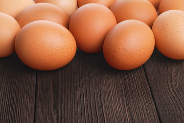 Closeup front view of brown fresh chicken eggs on wooden rural rustic background with copy space