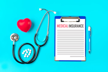 Phonendoscope, heart, tablet with white paper, pen, medicine on blue background Health, life,...