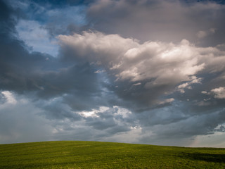 Paisaje de campo verde con cielo de nubes de tormenta.