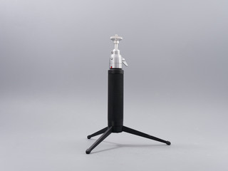 metal mini tripod for the camera on a gray background