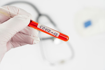 Obraz premium Hand with a laboratory tube with blood sample and the imprint Covid-19