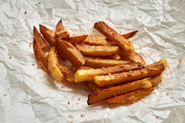 Tasty homemade potato french fries on white paper background