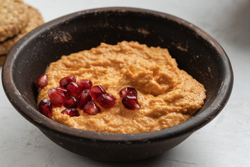 Hummus with roasted bell pepper and pomegranate seeds