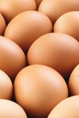 Vertical photo of fresh brown chicken eggs. Abstract food pattern. Modern rustic texture background